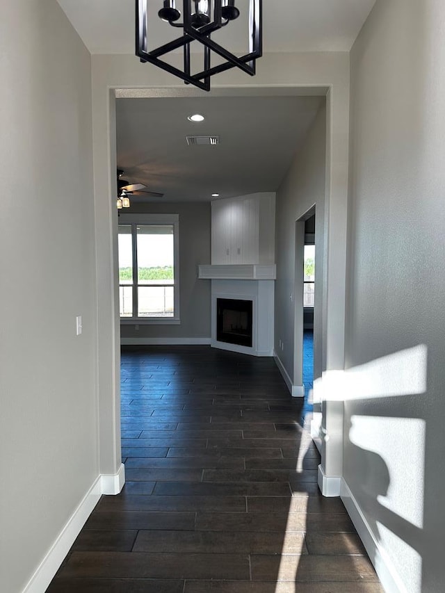 5610 Slayde St, San Angelo, TX 76904 - unfurnished living room featuring baseboards, a chandelier, dark wood-style flooring, and healthy amount of natural light