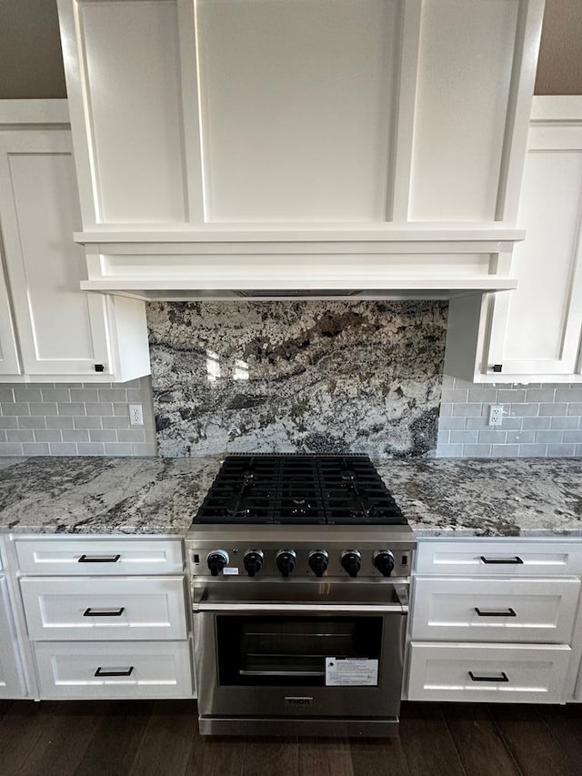 5610 Slayde St, San Angelo, TX 76904 - kitchen with stainless steel stove, white cabinets, tasteful backsplash, and light stone countertops