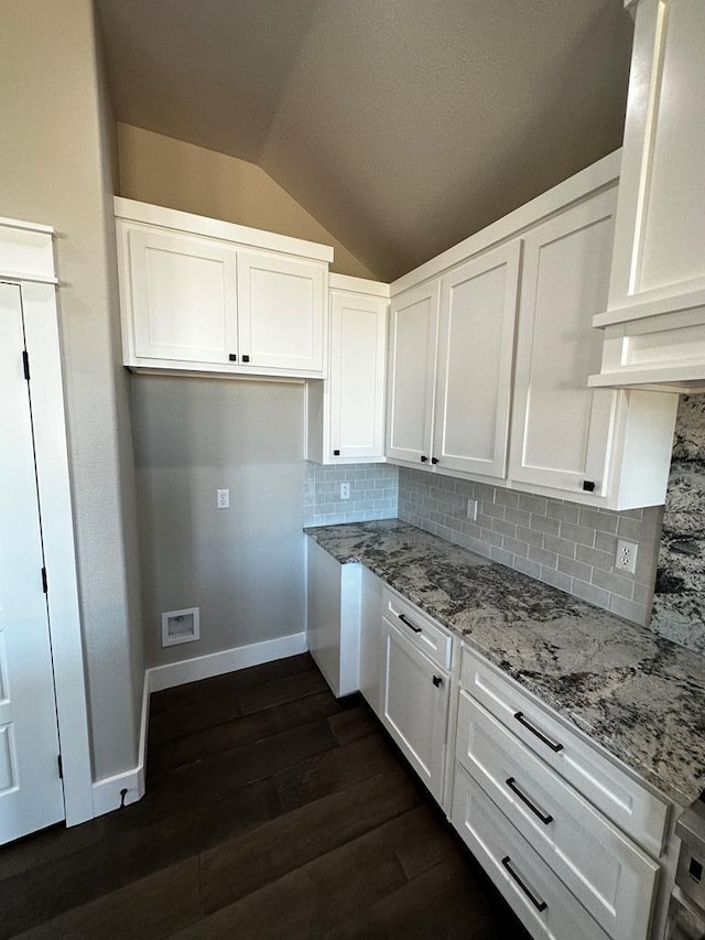 5610 Slayde St, San Angelo, TX 76904 - kitchen featuring vaulted ceiling, white cabinets, baseboards, light stone countertops, and dark wood-style floors