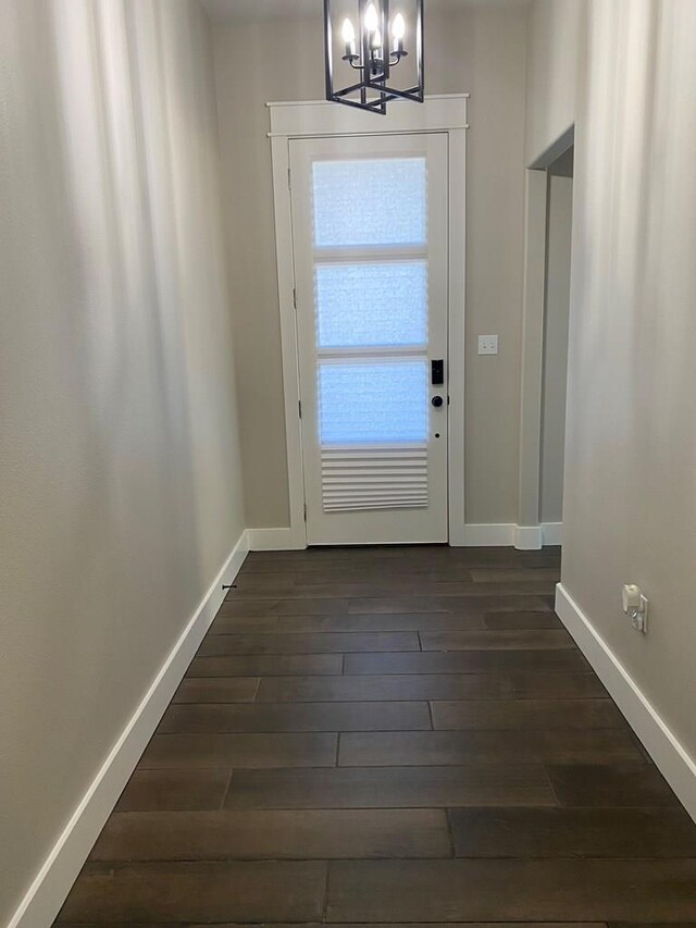 5610 Slayde St, San Angelo, TX 76904 - entryway featuring a chandelier, dark wood finished floors, and baseboards