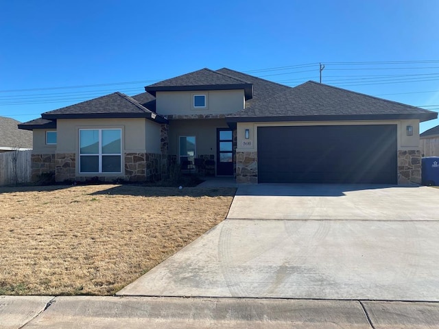 5610 Slayde St, San Angelo, TX 76904 - view of front of home with stone siding, an attached garage, concrete driveway, and stucco siding