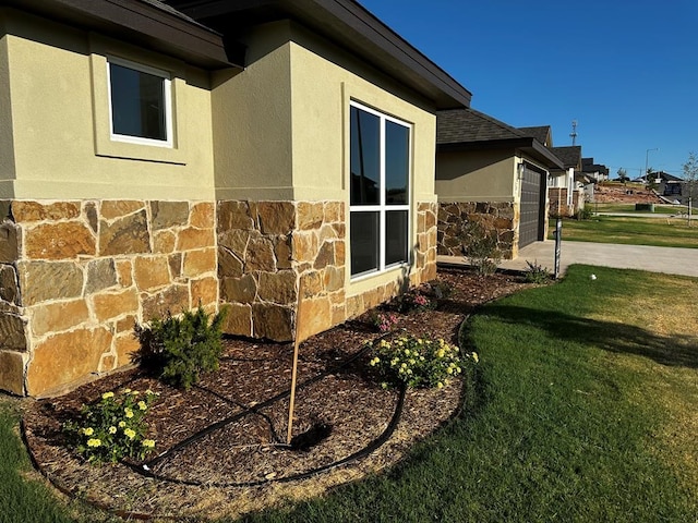 5610 Slayde St, San Angelo, TX 76904 - view of home's exterior with stone siding, a garage, stucco siding, and a yard