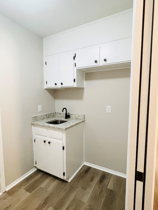 laundry area featuring sink and dark hardwood / wood-style flooring