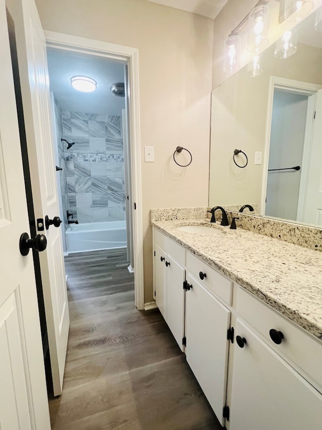 bathroom with vanity, hardwood / wood-style floors, and tiled shower / bath combo