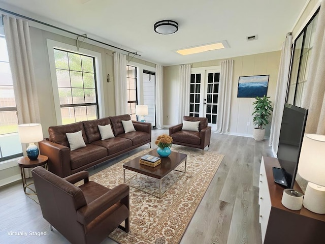 living room featuring french doors and light hardwood / wood-style floors