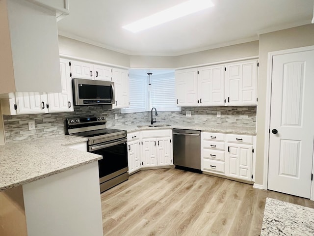 kitchen with white cabinetry, sink, kitchen peninsula, stainless steel appliances, and light stone countertops