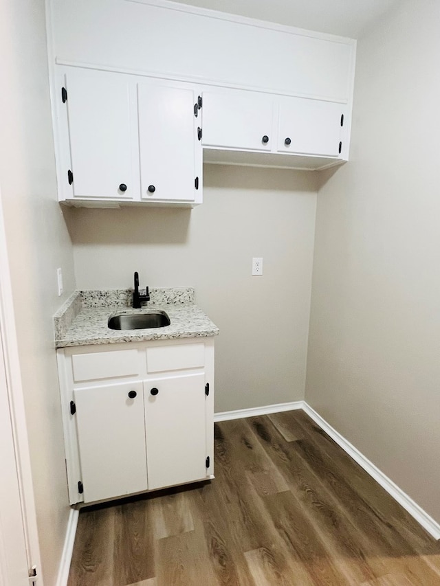 laundry area featuring sink and dark wood-type flooring