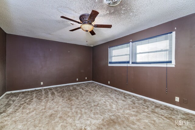 carpeted spare room with a textured ceiling and ceiling fan