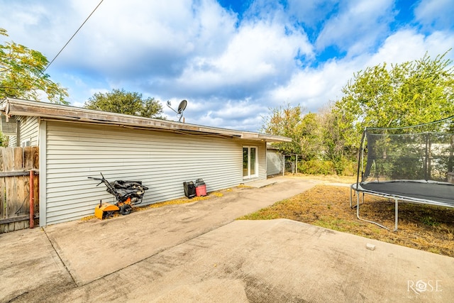 back of house featuring a trampoline and a patio area