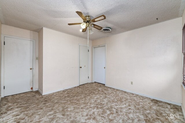 carpeted spare room featuring ceiling fan and a textured ceiling