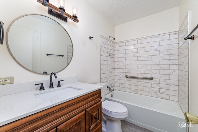 full bathroom with vanity, toilet, tiled shower / bath combo, and a textured ceiling