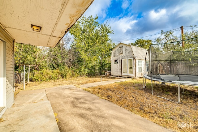 view of yard featuring an outbuilding, a patio area, and a trampoline