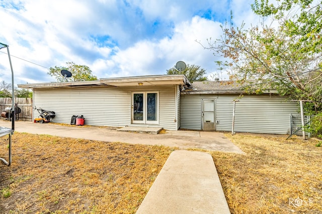 rear view of house with a patio area and a lawn