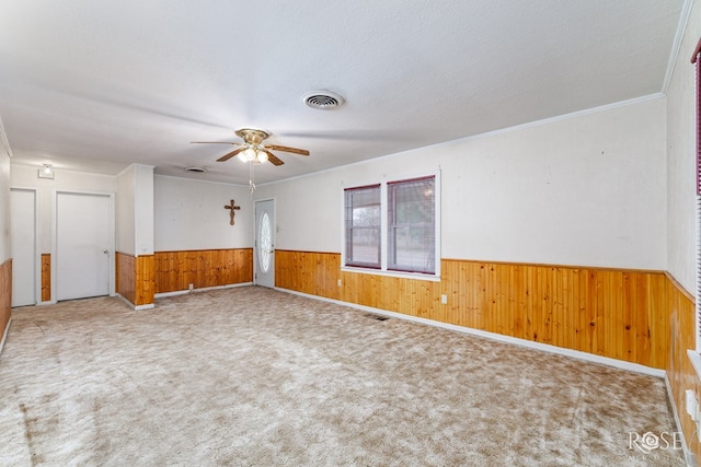 unfurnished room featuring ceiling fan, carpet floors, ornamental molding, and a textured ceiling