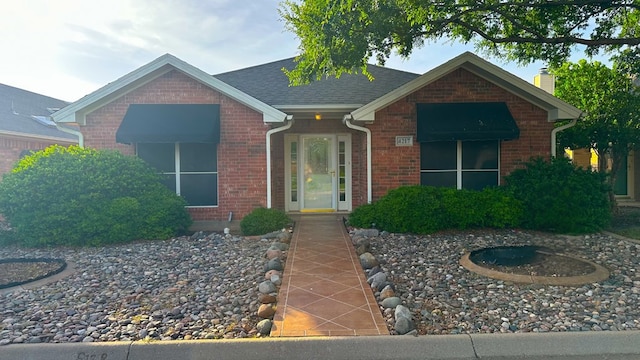 view of front of home featuring brick siding and a chimney