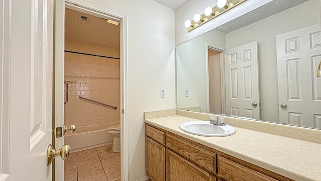 full bath featuring toilet, vanity, tile patterned floors, and shower / bath combination