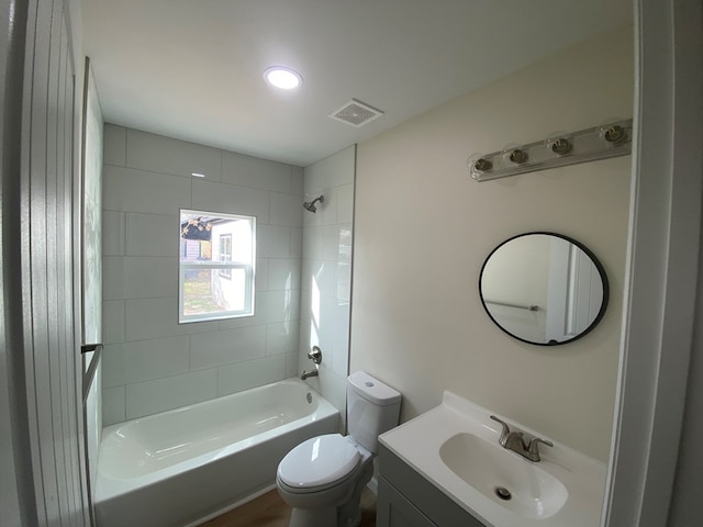 full bathroom with vanity, tiled shower / bath combo, toilet, and hardwood / wood-style flooring