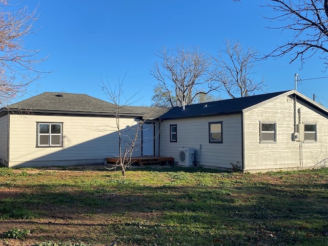 back of house with ac unit and a yard