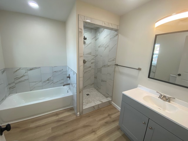 bathroom with shower with separate bathtub, hardwood / wood-style floors, and vanity