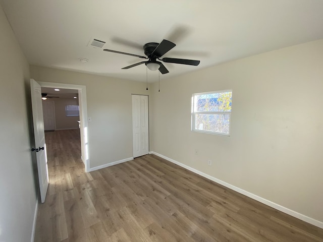 unfurnished bedroom with ceiling fan, hardwood / wood-style floors, and a closet