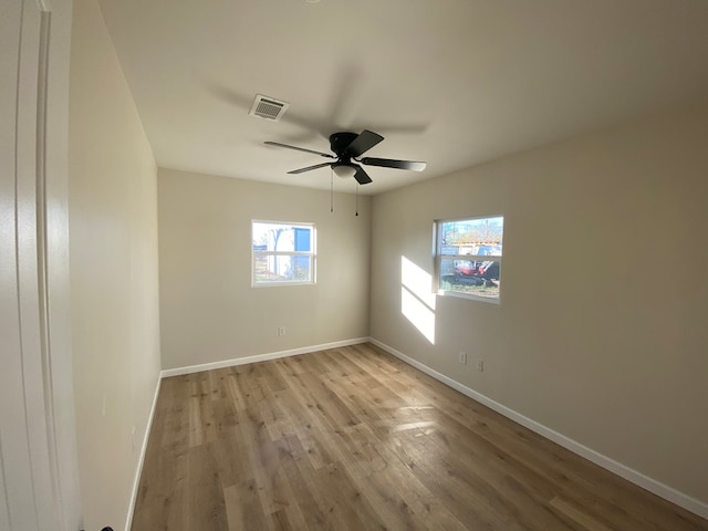 empty room with ceiling fan and light hardwood / wood-style floors