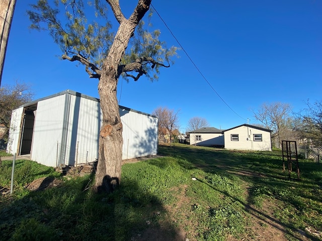 view of property exterior featuring an outbuilding and a lawn