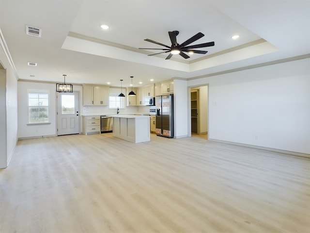 kitchen with stainless steel appliances, a center island, and a tray ceiling