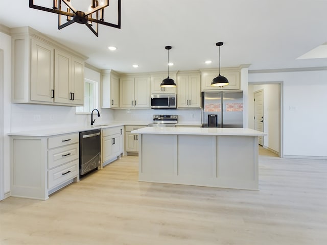 kitchen featuring sink, appliances with stainless steel finishes, a center island, tasteful backsplash, and decorative light fixtures