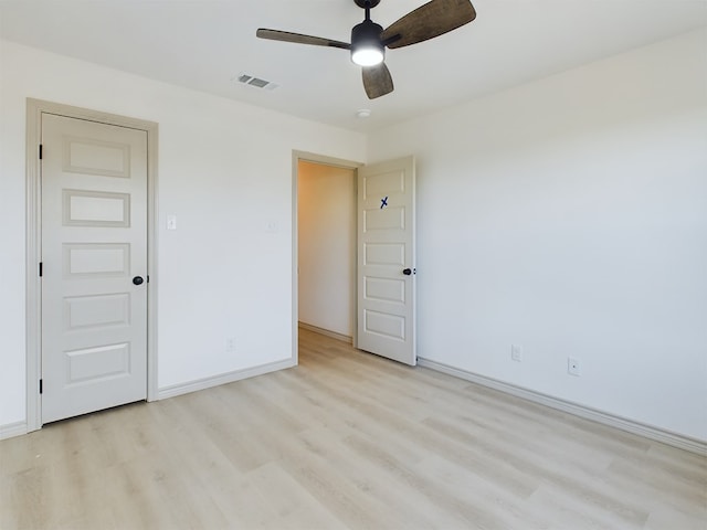 spare room with ceiling fan and light wood-type flooring