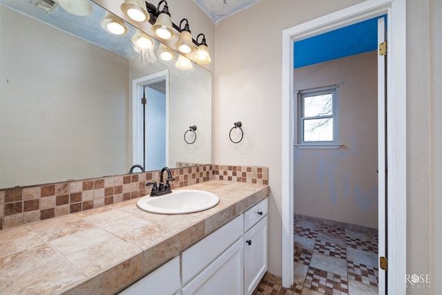 bathroom featuring vanity and decorative backsplash