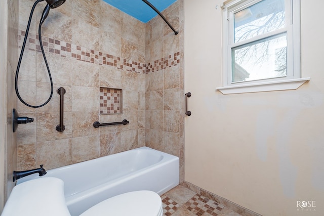 bathroom with toilet, tiled shower / bath combo, and tile patterned flooring