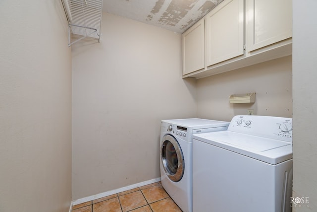 laundry area featuring cabinets, light tile patterned floors, and washer and dryer