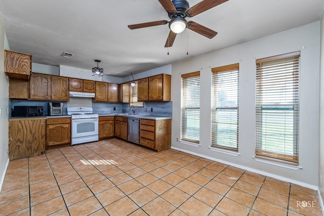 kitchen featuring light tile patterned floors, sink, tasteful backsplash, white gas range, and stainless steel dishwasher