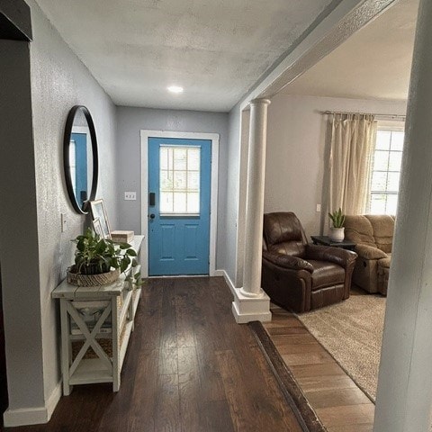 entrance foyer featuring dark hardwood / wood-style flooring and decorative columns