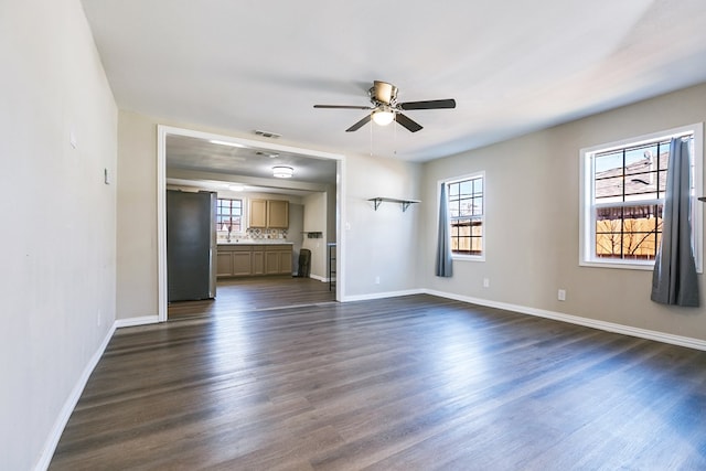 106 W 27th St, San Angelo, TX 76903 - unfurnished living room featuring ceiling fan and dark wood finished floors