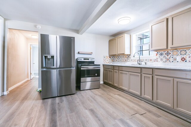 106 W 27th St, San Angelo, TX 76903 - kitchen with stainless steel appliances, beamed ceiling, light wood-style flooring, tasteful backsplash, and light countertops