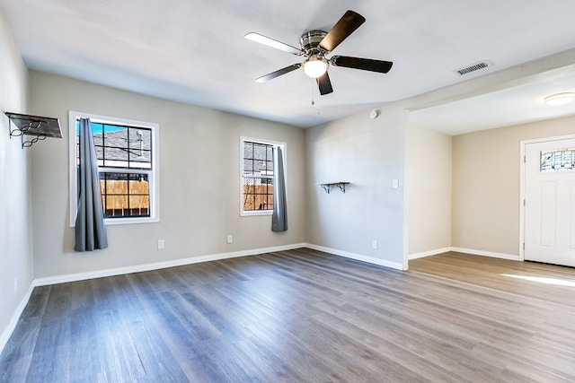 106 W 27th St, San Angelo, TX 76903 - spare room with healthy amount of natural light, wood finished floors, and a ceiling fan