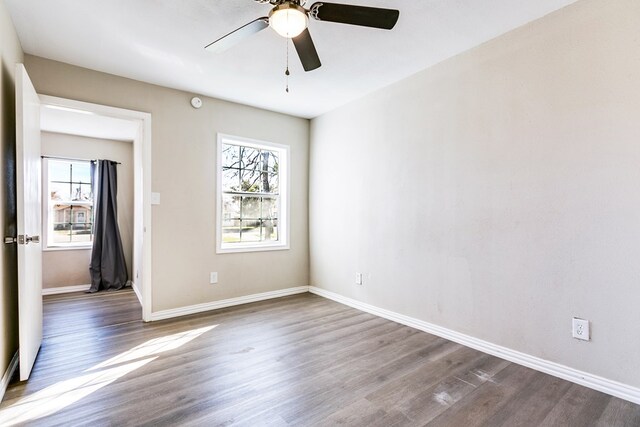 106 W 27th St, San Angelo, TX 76903 - spare room with healthy amount of natural light, dark wood finished floors, and a ceiling fan