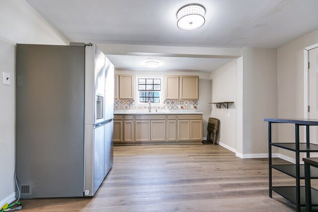 106 W 27th St, San Angelo, TX 76903 - kitchen with stainless steel fridge with ice dispenser, light wood-type flooring, decorative backsplash, and light countertops