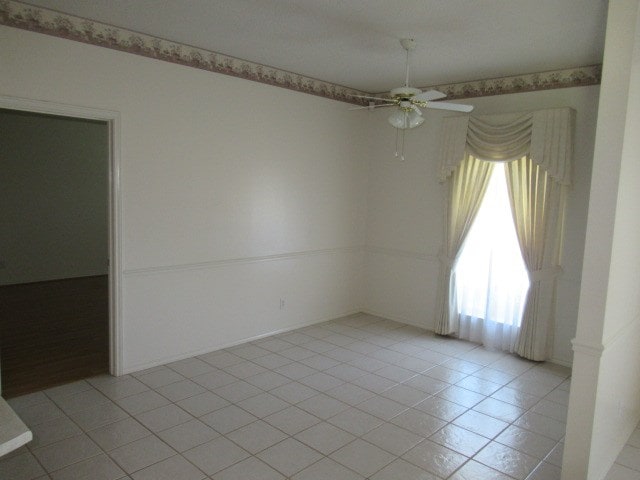 empty room with light tile patterned floors and ceiling fan