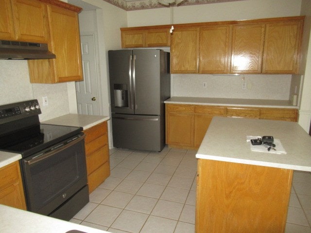 kitchen featuring under cabinet range hood, stainless steel fridge with ice dispenser, light countertops, black range with electric stovetop, and light tile patterned floors