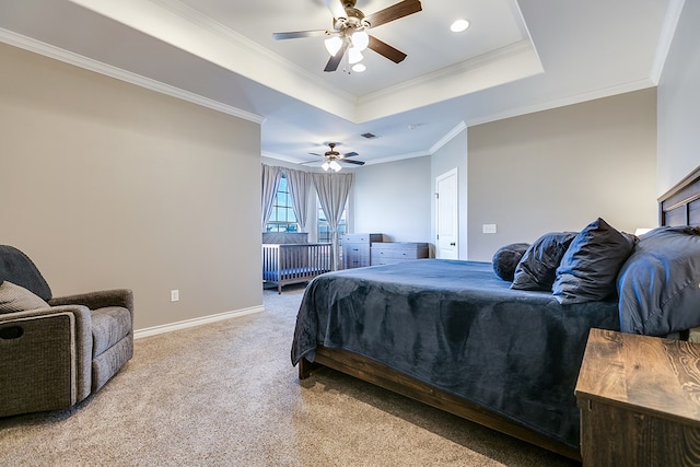 carpeted bedroom featuring ornamental molding, ceiling fan, and a tray ceiling