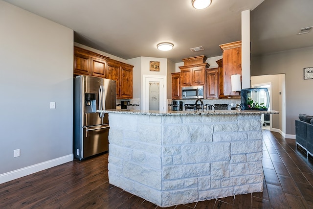 kitchen featuring tasteful backsplash, sink, dark hardwood / wood-style flooring, stainless steel appliances, and light stone countertops