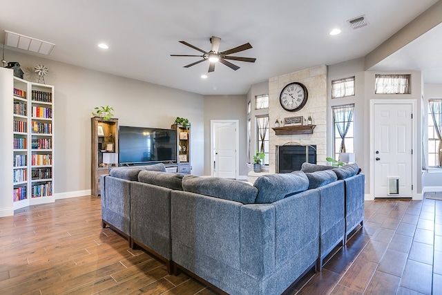 living room with ceiling fan and a fireplace