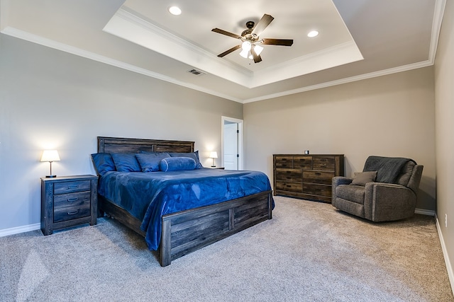 bedroom featuring ornamental molding, light colored carpet, ceiling fan, and a tray ceiling