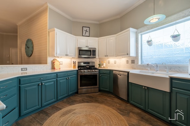 kitchen featuring appliances with stainless steel finishes, pendant lighting, white cabinetry, sink, and decorative backsplash