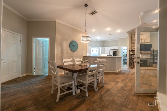 dining area with crown molding and dark wood-type flooring