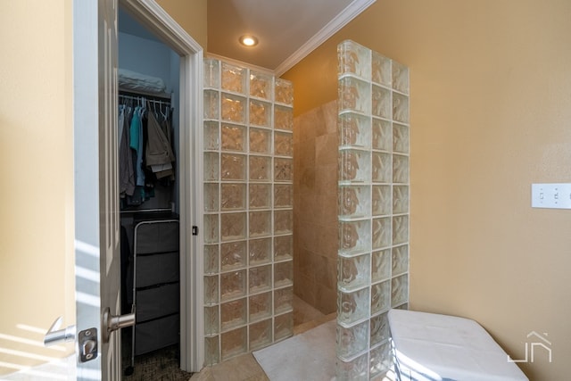 bathroom with crown molding, tiled shower, and tile patterned floors