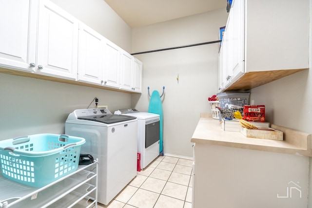 laundry area featuring cabinets, light tile patterned flooring, and separate washer and dryer