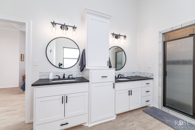 bathroom with vanity, an enclosed shower, and wood-type flooring